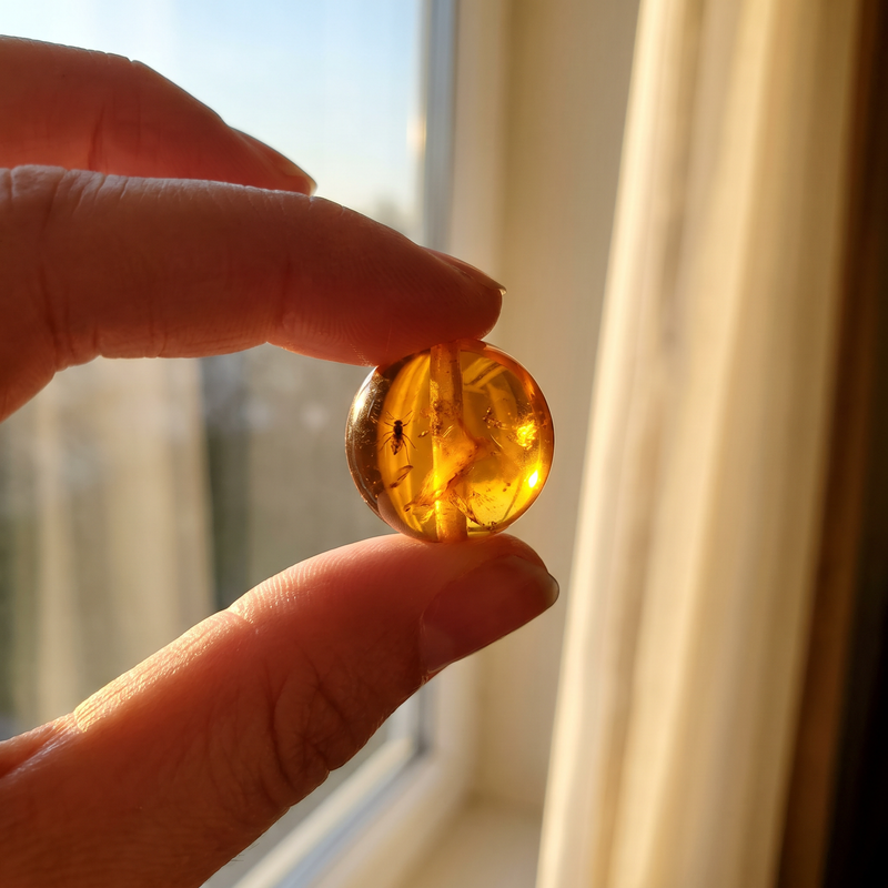A single glowing amber bead held up to the light